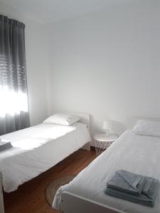 a bedroom with two beds and a window at Buddies Family Room in Aveiro +1 photo