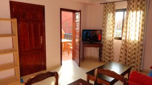 un salon avec une télévision et une chambre avec une table dans l'établissement Small&Sunny WiFi Premium vivienda vacacional, à Corralejo