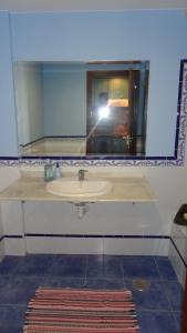 une personne prenant une photo d'un lavabo dans une salle de bains dans l'établissement Small&Sunny WiFi Premium vivienda vacacional, à Corralejo