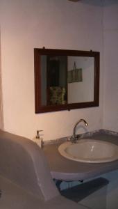 La salle de bains est pourvue d'un lavabo et d'un miroir. dans l'établissement La Vigne Bleue, à Olonzac