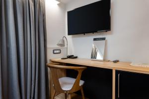 a desk with a monitor and a chair in a room at Hotel Peteani in Labin