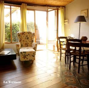 a living room with a chair and a table at La Vigne Bleue in Olonzac