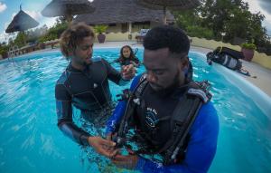 dos hombres en el agua en una piscina en Butiama Marine Camp, en Utende