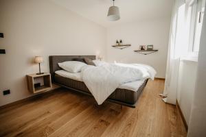 1 dormitorio con 1 cama y suelo de madera en Haus Wildmoos, en Sankt Martin bei Lofer