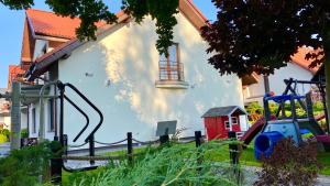 un edificio blanco con un parque infantil delante de él en Rosa Park, en Rowy