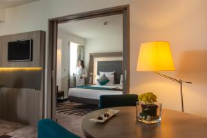 um quarto de hotel com uma cama e um espelho em Novotel Cairo Airport no Cairo