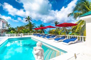 einen Pool im Resort mit Stühlen und Sonnenschirmen in der Unterkunft Butterfly Cottage at Viking Hill - Love Beach in Nassau