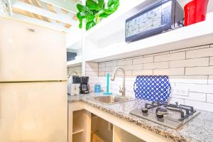 a kitchen with a sink and a refrigerator at Butterfly Cottage at Viking Hill - Love Beach in Nassau