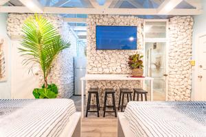 a bedroom with two beds and a tv on a wall at Butterfly Cottage at Viking Hill - Love Beach in Nassau