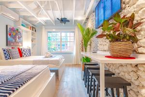 a room with a bed and a table with plants at Butterfly Cottage at Viking Hill - Love Beach in Nassau +16 photos