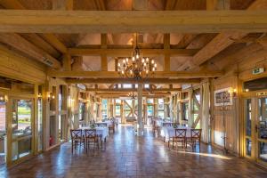 a dining hall with tables and chairs and a chandelier at Alauso Slenis in Sudeikiai