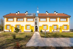 a large yellow building with a red roof at Gold Oasi - Business Solution in Ferrara