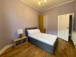 a bedroom with a bed and a lamp and a door at innerCityLets - Royal Mile in Edinburgh