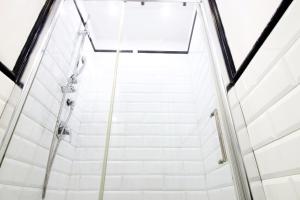 a shower stall in a building with white tiles at L'antica Locanda Dell'Orso in Rome