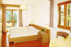 Schlafzimmer mit einem Bett, einem Tisch und einem Fenster in der Unterkunft Gasthaus Gasteiger in Algund