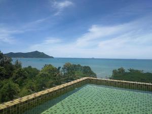 a swimming pool with a view of the ocean at De Amber Bang Sarae by FunnyProperty in Bang Sare