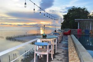 a row of tables and chairs on a dock near the beach at Ocean Terrace Suite And Spa Luxury in Nusa Penida