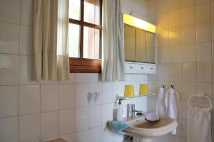 a white bathroom with a sink and a window at Jardin de Aridane in El Paso