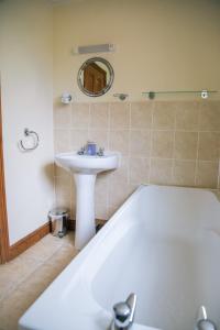 bagno con lavandino, vasca e lavandino di Millmoor Farm Holidays a Malpas