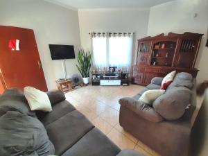 a living room with two couches and a television at Hotel Vila Solar in Limeira