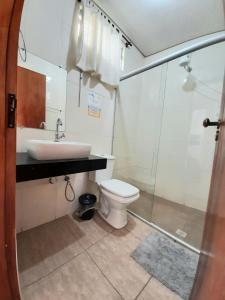 a bathroom with a toilet and a sink and a shower at Hotel Vila Solar in Limeira