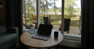 laptopa siedzącego na stole przed oknem w obiekcie LapinTintti Eco-Cabin in Inari w mieście Inari