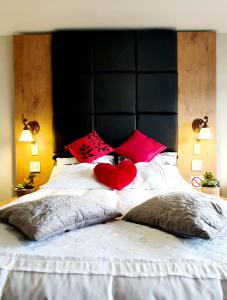 クルーガーズドープにあるHyswan Self Catering Guesthouseの黒いヘッドボードと赤いハートが付いたベッド