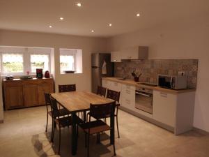 a kitchen with a wooden table and chairs in a kitchen at Gite le Nid du Poupet in Ivrey