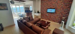 a living room with a couch and a brick wall at amravati resort in Solan
