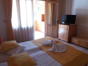 a bedroom with a large white bed with a television at Vila Sara/Adult Only in Sovata