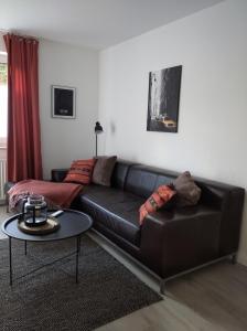 salon z czarną skórzaną kanapą i stołem w obiekcie Apartment24 w mieście Lügde