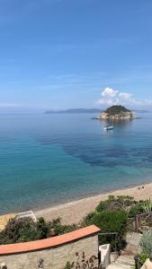 a view of a beach with a boat in the water at PUNTA dei BARBARI #MAESTRALE #LIBECCIO #TRAMONTANA in Cavo