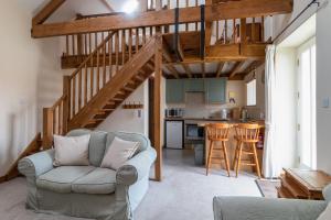 a living room with a couch and a kitchen at Prospect Farm Cottages in Allerston