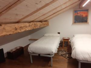 a room with two beds in a attic at Casa Sicina in Sicina