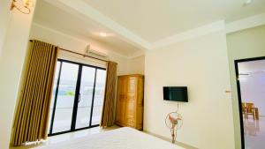 フエにあるHue Classic Hotelのベッドと壁掛けテレビのある寝室