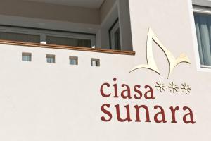 a sign on the side of a building with a clasena sierra logo at Ciasa Sunara in Colfosco