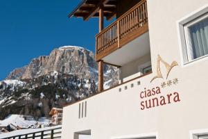 un hôtel avec une montagne en arrière-plan dans l'établissement Ciasa Sunara, à Colfosco