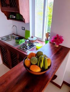 a bowl of fruit on a wooden counter in a kitchen at Simba House in Watamu