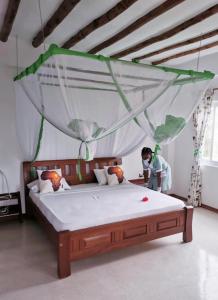 a person taking a picture of a bed in a room at Simba House in Watamu