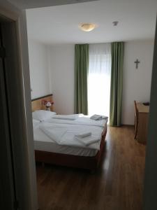 a bedroom with a bed and a window at Hotel Dina in Međugorje
