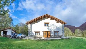 una pequeña casa blanca con un coche aparcado al lado en Casa Rural Borda Lenco, en Cilveti