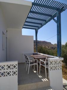 a pergola with a table and chairs on a patio at Albatros Studios & Apartments in Lefkos Karpathou