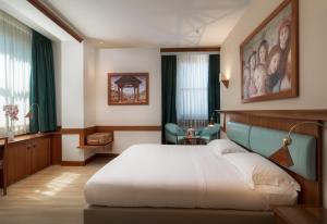 a hotel room with a bed and a painting on the wall at Sangallo Palace in Perugia