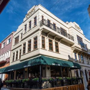 un edificio blanco con toldo verde en una calle en Ortaköy Hotel en Estambul