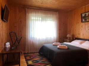 ein Schlafzimmer mit einem Bett und einem Fenster mit einem Vorhang in der Unterkunft Котедж на Довбуша in Jaremtsche