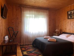 a bedroom with a bed and a window with a curtain at Котедж на Довбуша in Yaremche