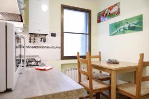 eine Küche mit einem Tisch und Stühlen sowie einem Fenster in der Unterkunft Appartamento San Marco Frezzaria in Venedig