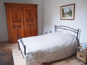 a bedroom with a bed and a wooden cabinet at Gîte des Arts in Ammerschwihr