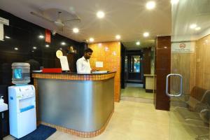 a man standing at a counter in a restaurant at Hotel Sona in Panaji