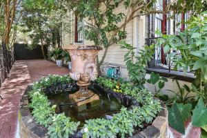 um jardim com um vaso no meio das plantas em The Mansion on Royal em Nova Orleães